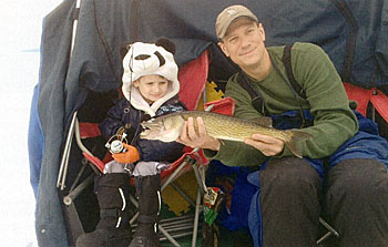 My husband and little boy in the ice shanty with a big catch.