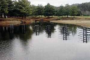 Notice these structures are placed in bunches of three, at a specific depth, where the water will rise two to three feet above them.