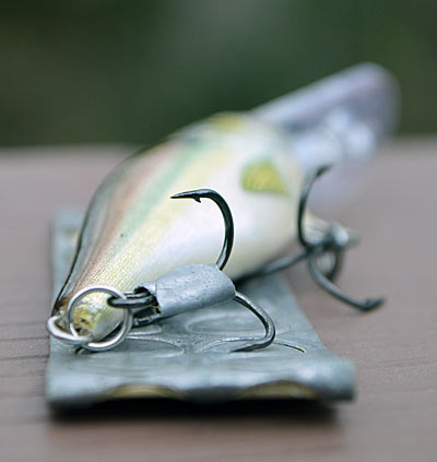 Casting small wood flat-sided crankbaits in the wind will test the patience of the calmest angler. Guide and former Bassmaster Elite Series angler Travis Manson adds lead tape to the rear hook’s shank to improve casting distance and accuracy. Photo by Pete M. Anderson