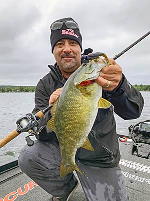 Zona with a nice smallmouth caught in three-feet of water.