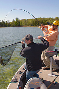 Matt Gnatkowski slips to net under a smallmouth caught by Dave Rose.