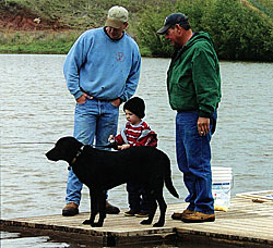 Sherman Wyman, left, with Mike Payne and Mike's grandson Kagen as the youngster makes a heyday of his fishing trip.