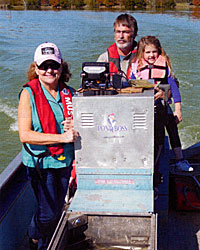 Bob and Debbie Lusk with granddaughter, Jentry, in Bob's electrofishing boat.