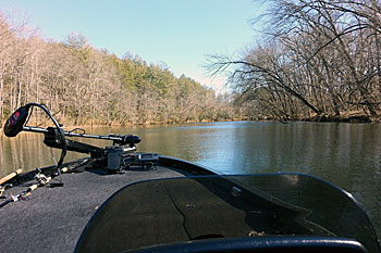 When river current runs fast, bass head to the bank, finding shelter behind solid pieces of cover such as large logjams, points or rocks.