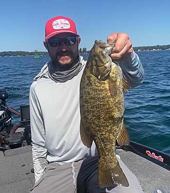 A big smallmouth caught just downriver from a marker buoy, indicating a large rock pile and drop-off along the river channel.