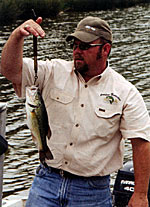 Fisheries biologist Clint Wilson weighs a bass to determine body condition to make a recommendation to the landowner.