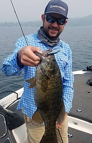 The author, with a smallmouth bass caught with a spybait on a summer day in the Pacific Northwest.