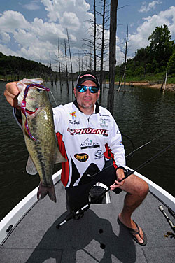 Kevin Smith pitches magnum plastic worms and creature baits to standing timber to tempt bass suspended in the tree branches and limbs.