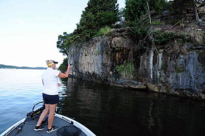 Missouri guide Denise Dill looks for any irregularities in bluffs to find summertime bass hangouts.