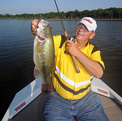 Heavy tackle and thick line are necessities for working a plastic worm through brush piles for summertime bass.