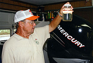 Bill Dance looks at a jar test. In 2006, the small lake next to his house was muddy. The jar test started the process to manage his water quality.